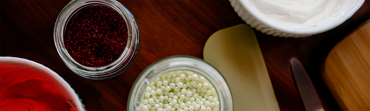 Multi-colored cake decorations and tools on a table.